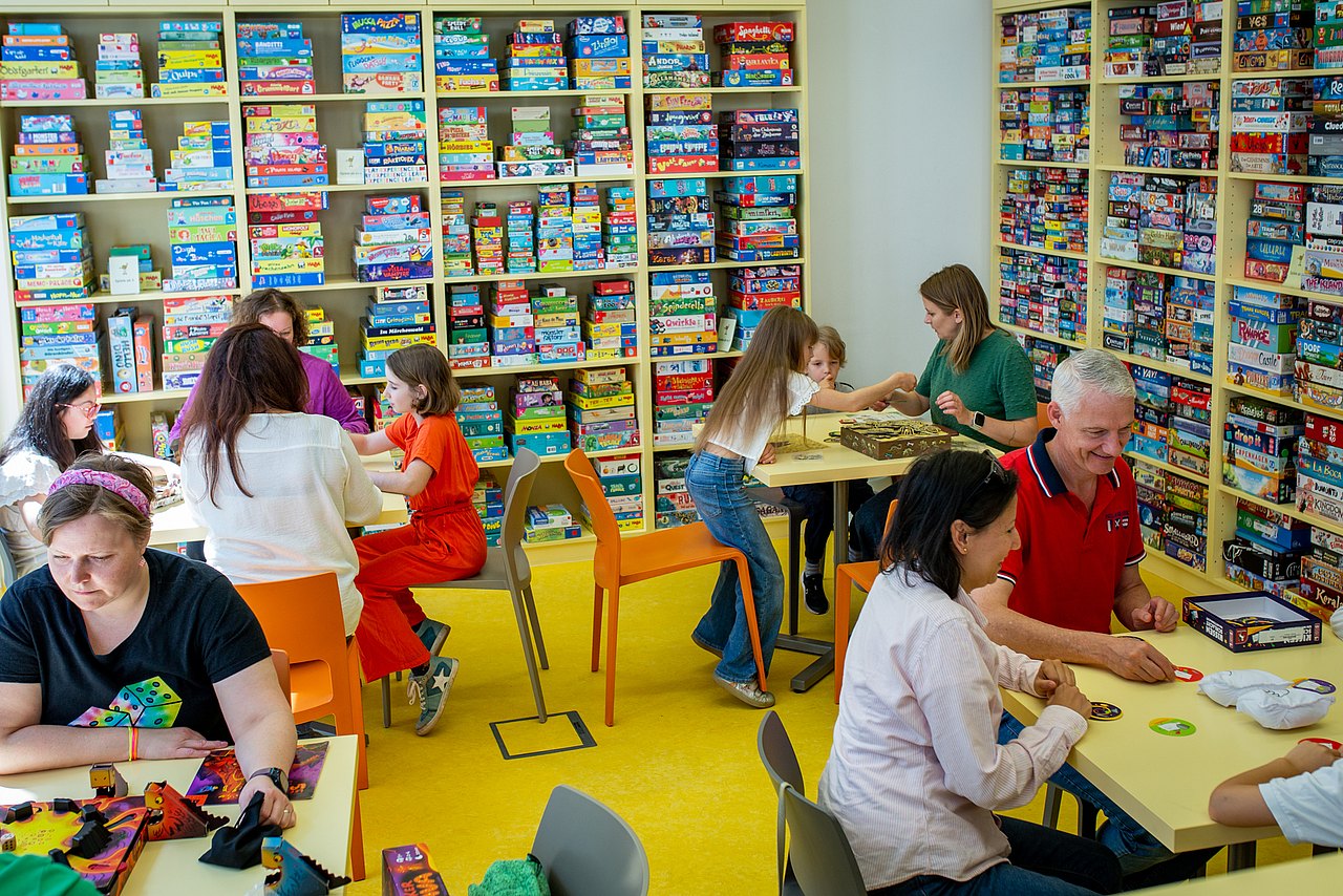 Familien spielen im Verleihraum der Spielebox Brettspiele.