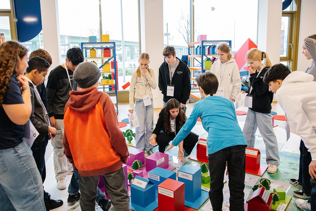 Jugendliche auf Stadtplan diskutieren über Stadtgestaltung