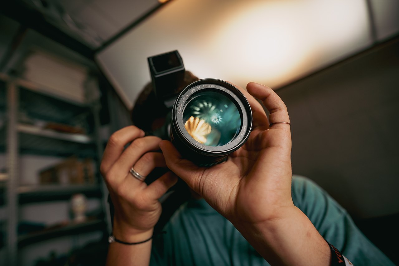 Ein Jugendlicher fotografiert mit einer professionellen Fotokamera in einem Studio.