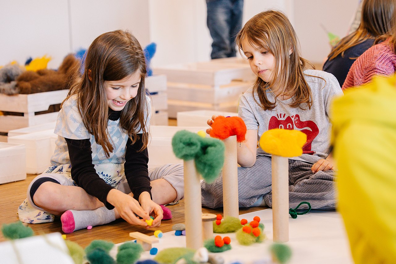 Kinder bauen an Traumstadt mit Modellbaumaterialien