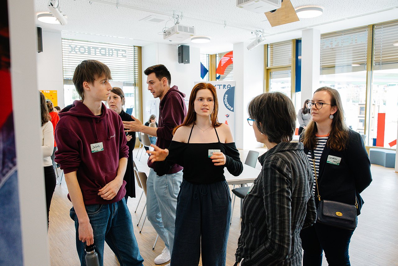 Personen stehen nebeneinander und sprechen miteinander