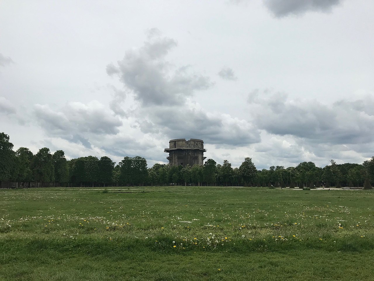 große Wiese und am Horizont ist ein Flakturm zu sehen
