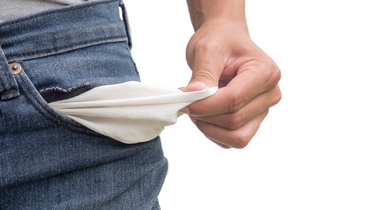 ein Mensch zeigt seine leere Hosentaschen ohne Geld 