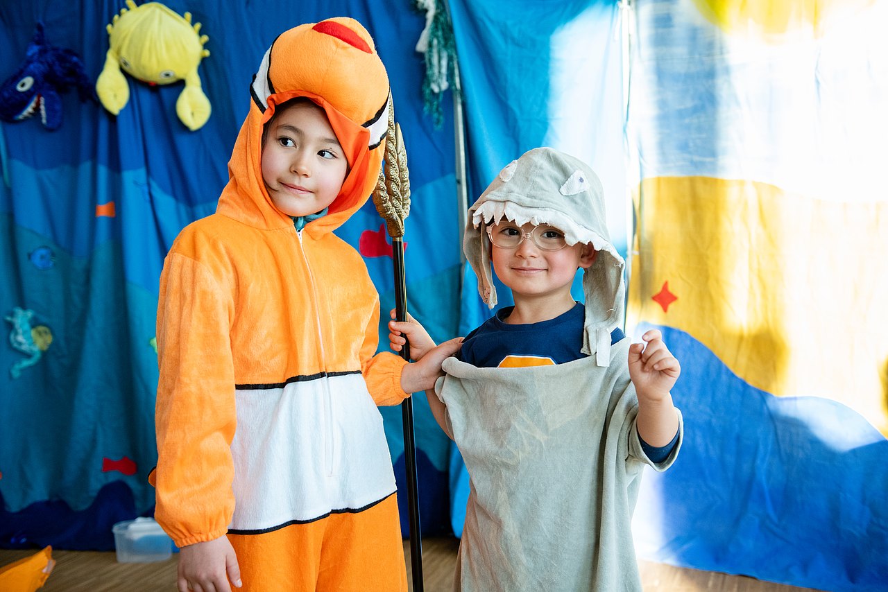 Mitmachtheater_Seestadt_c_Liebentritt_065 Kinder verkleidet als Fische vor blauem Unterwasser-Hintergrund