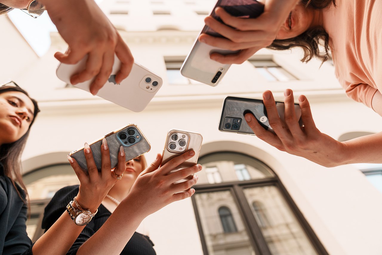 mz2025 x ste.krenn-212 Einige Jugendliche haben Smartphones in der Hand und schauen diese an.