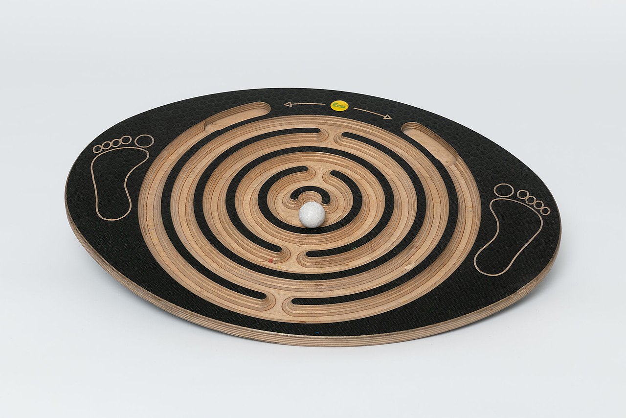 Holzplatte mit Labyrinth das mit einer Kugel gefahren werden soll.