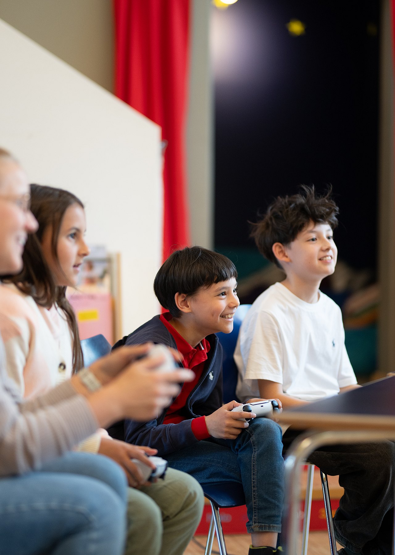 Erwachsene und Kinder spielen lachend an einer Konsole