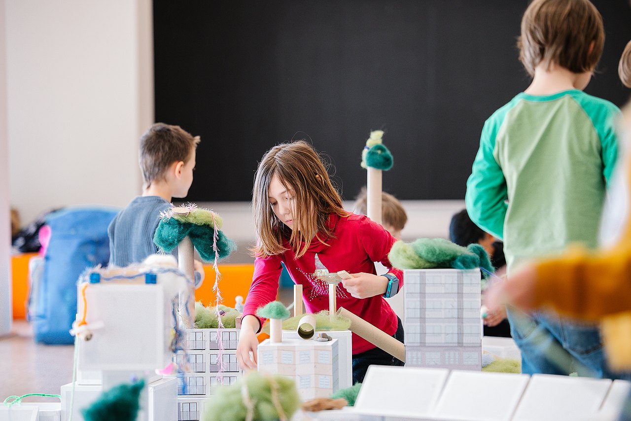 Kinder bauen mit Modellbaumaterialien ihre Traumstadt