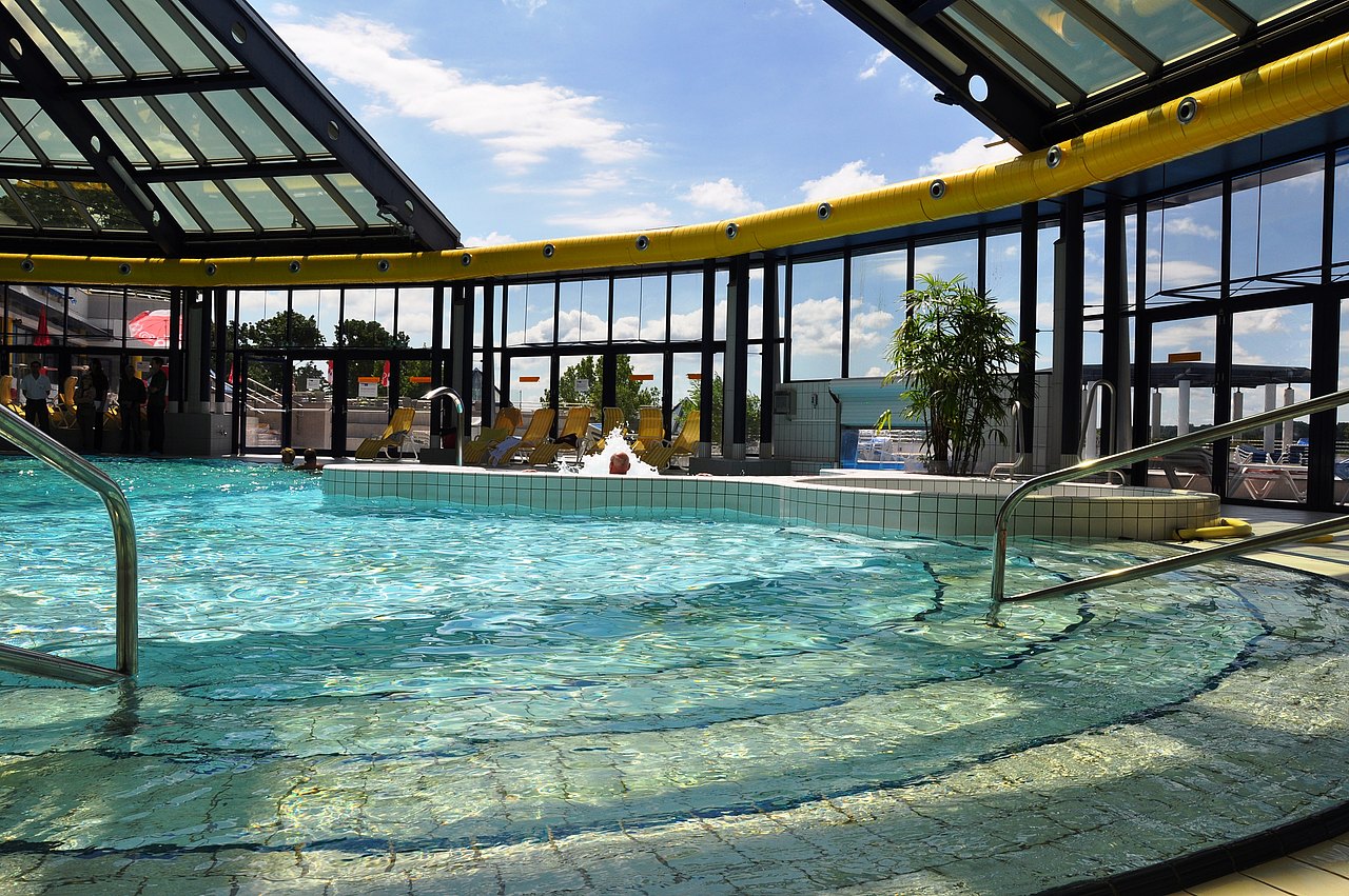 Schwimmbecken im Hallenbad mit offenem Glasdach