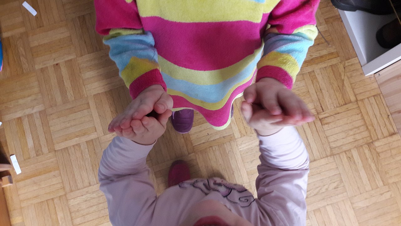 Kinder legen Hände zusammen.