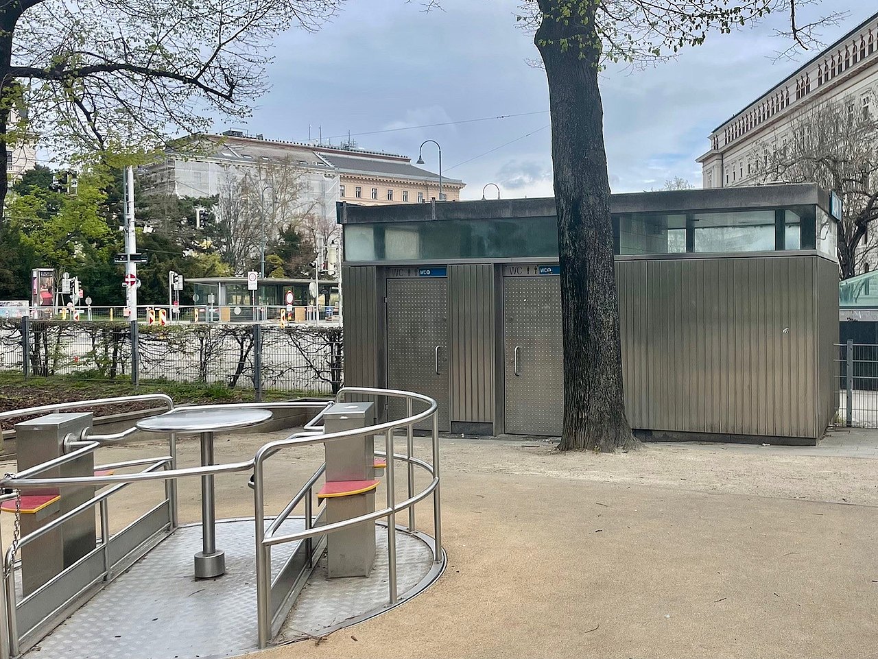Rollstuhltaugliches Karussell am Spielplatz Weghuberpark Im Vordergrung sieht man das Rollstuhltaugliche Karussell auf Fallschutzboden, dahinter ist die Toilettenanlage zu sehen