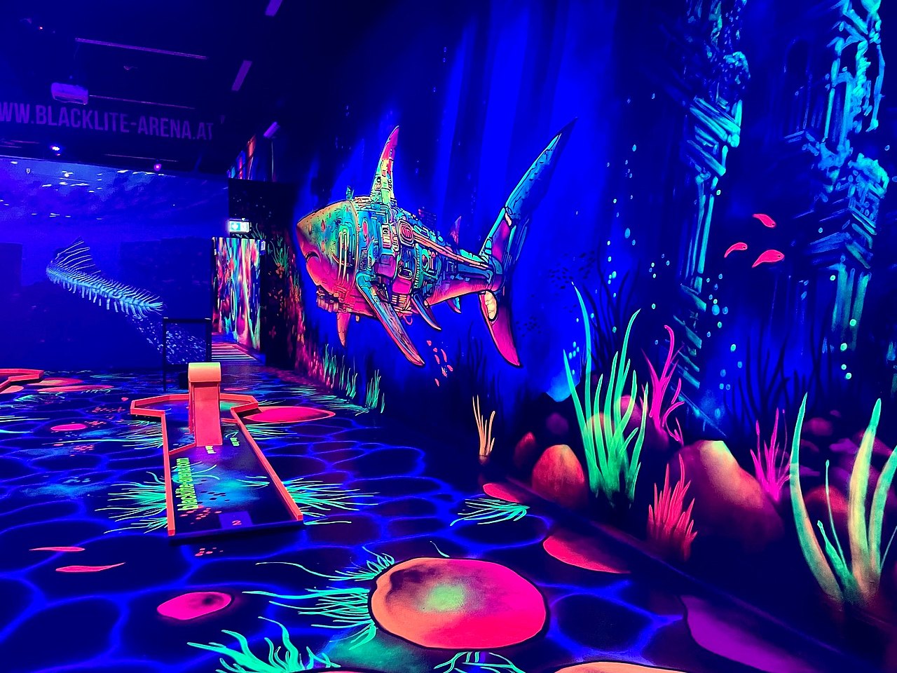 Erster Raum in der Minigolfanlage der Blacklite-Arena die wie eine Unterwasserwelt gestaltet ist mit Fischen und Meeerjungfrau