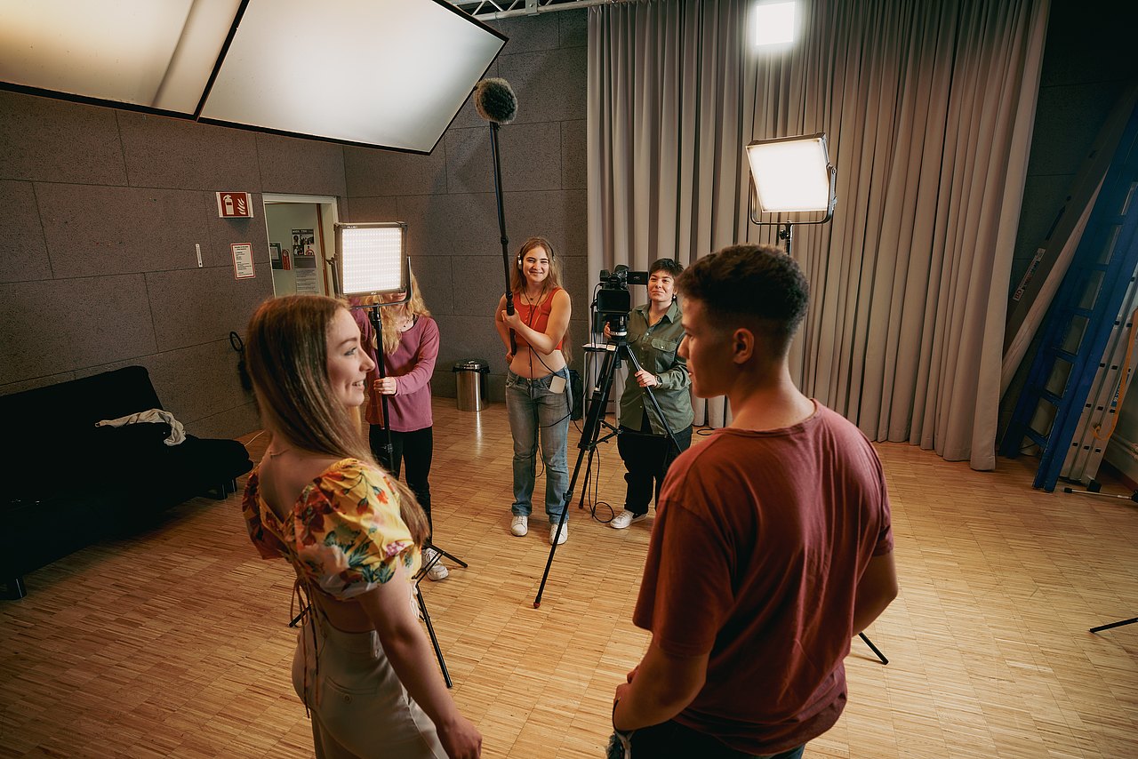 Eine Gruppe an Jugendlichen dreht einen Film in einem Studio.