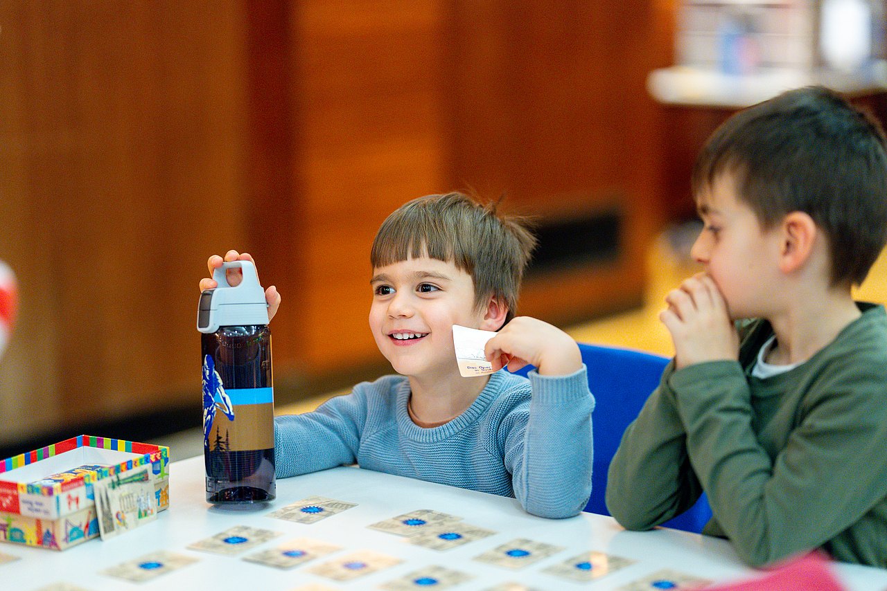 Kind bei Tisch mit Brettspiel