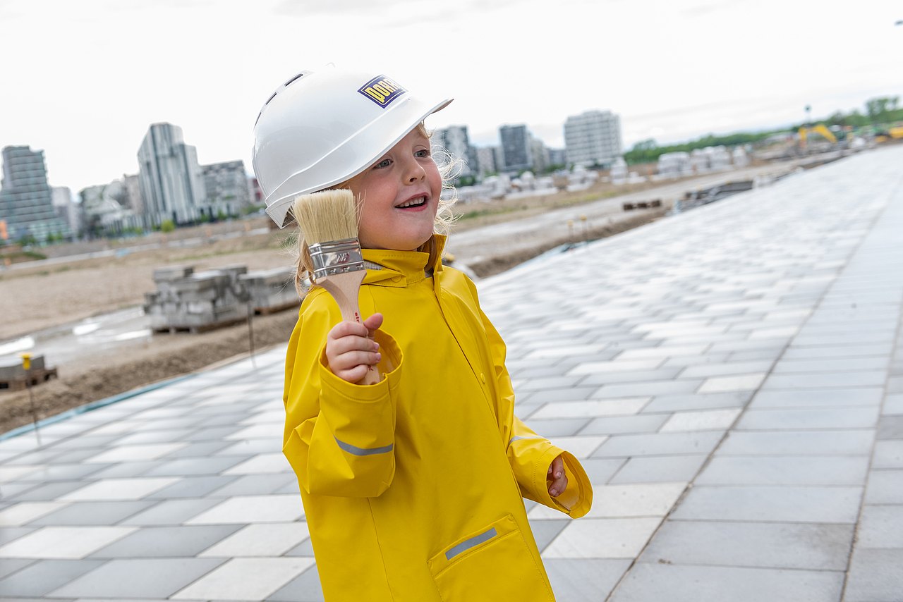 Kind mit Pinsel und Bauhelm