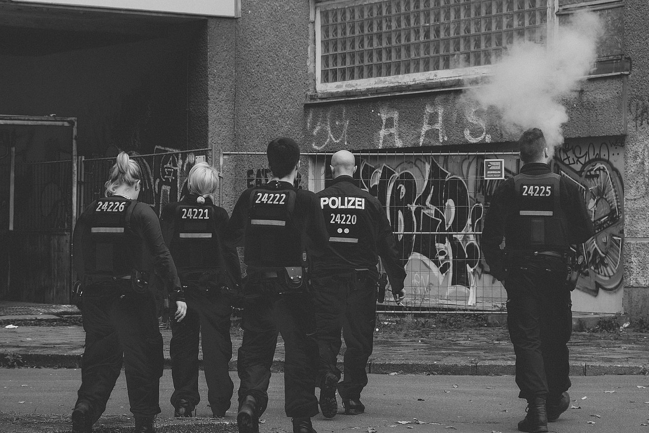 Polizeibeamte von hinten auf grauem Bild ohne Farbe