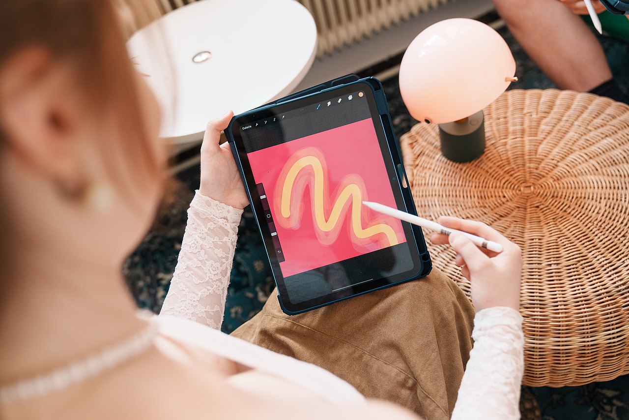 mz2025 x ste.krenn-55 Eine Jugendliche hält ein iPad in der Hand und zeichnet mit einem Stift darauf.