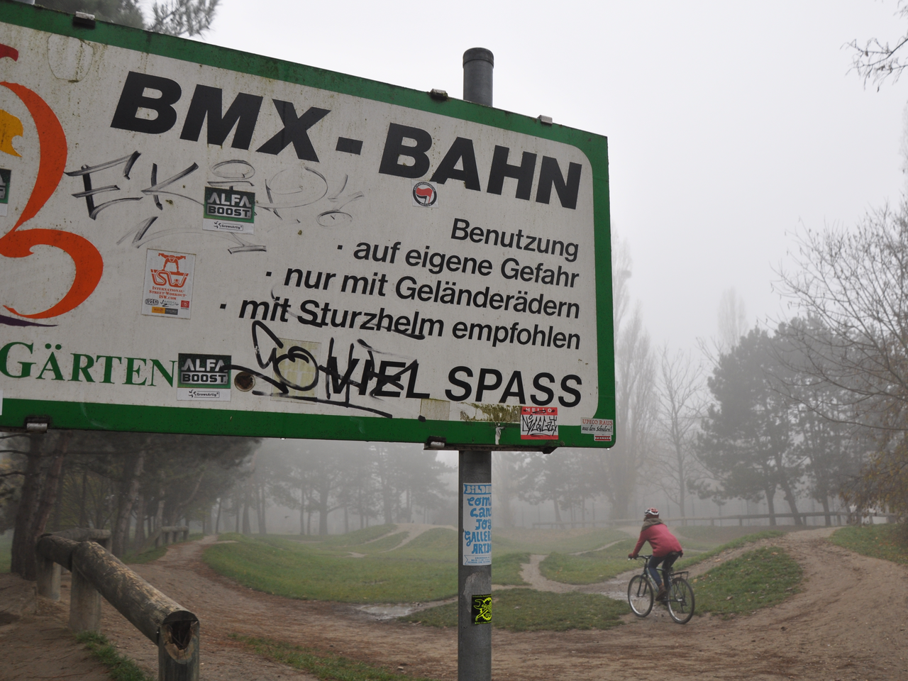 Schild mit Aufschrift BMX Bahn und Person auf einem Fahrrad