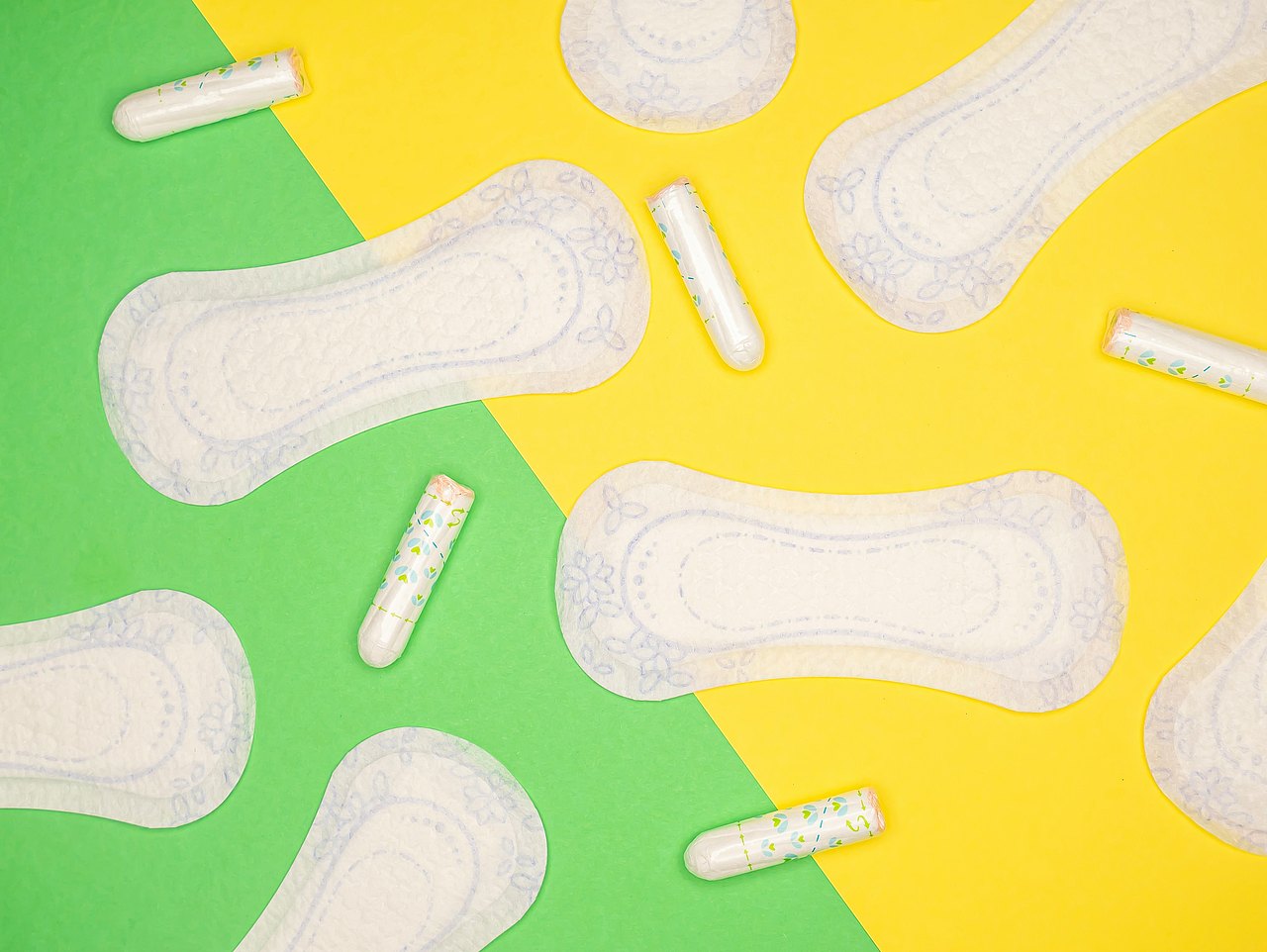 Binden und Tampons auf einem grün-gelben Tisch 
