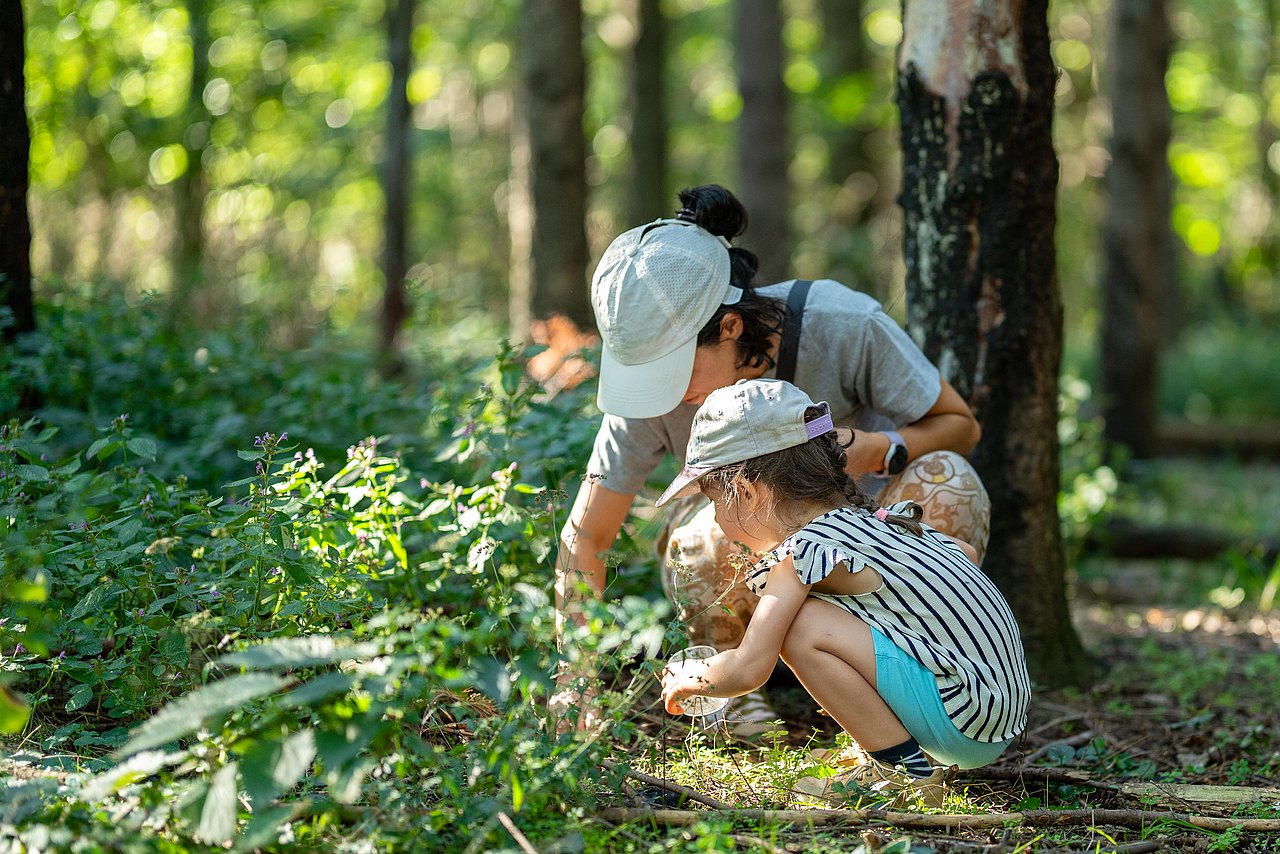 Mutter und Kind suchen etwas am Boden
