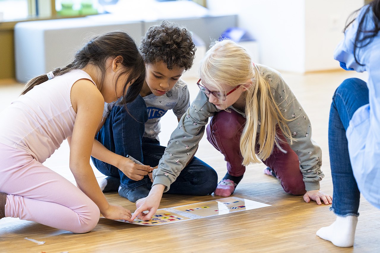 Kinder lösen zusammen ein Rätsel
