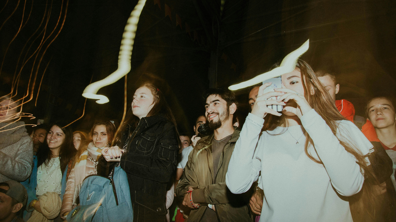 Junge fröhliche Menschen verfolgen ein Konzert.