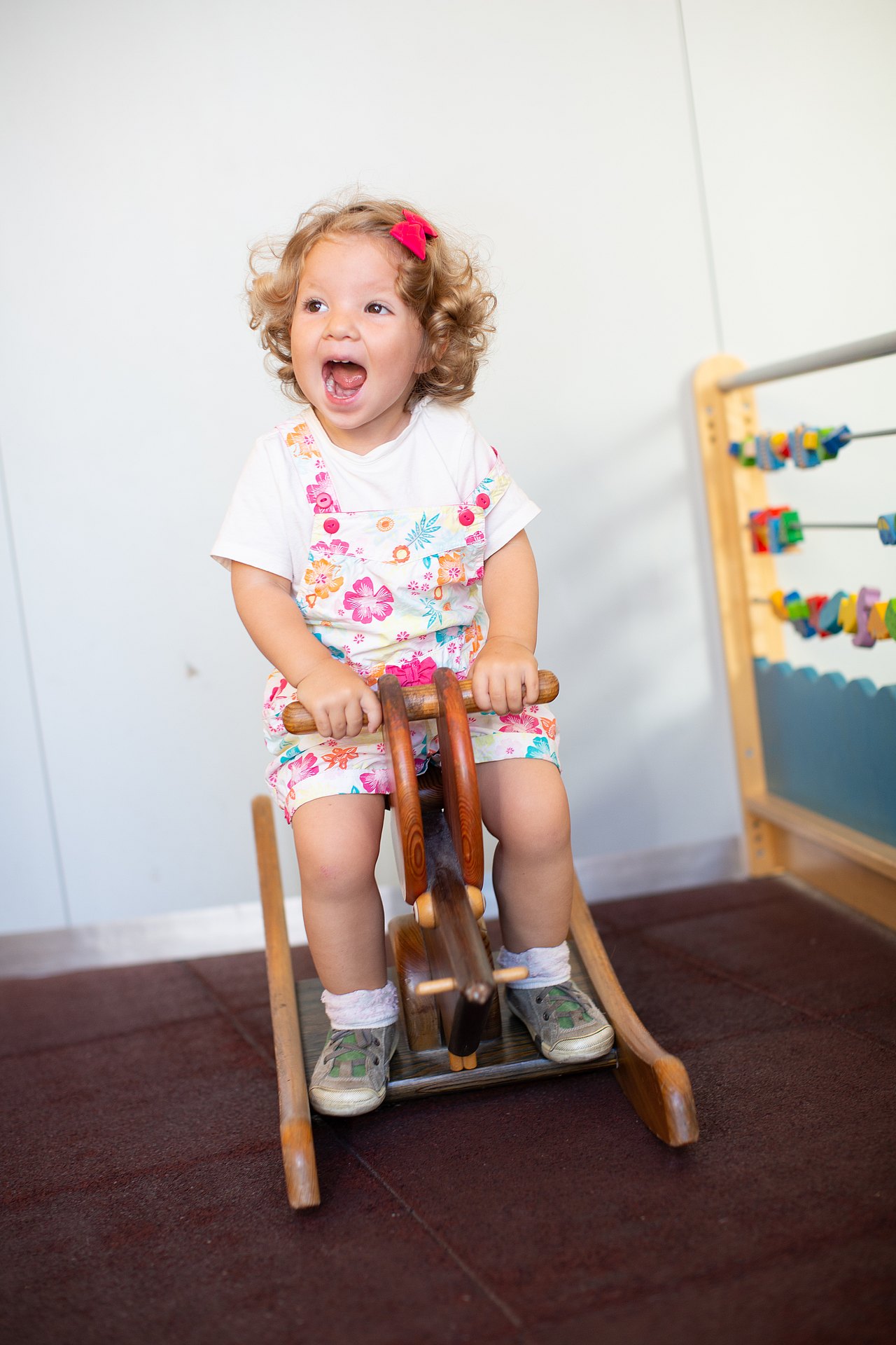 Kind sitzt auf Schaukelpferd und freut sich