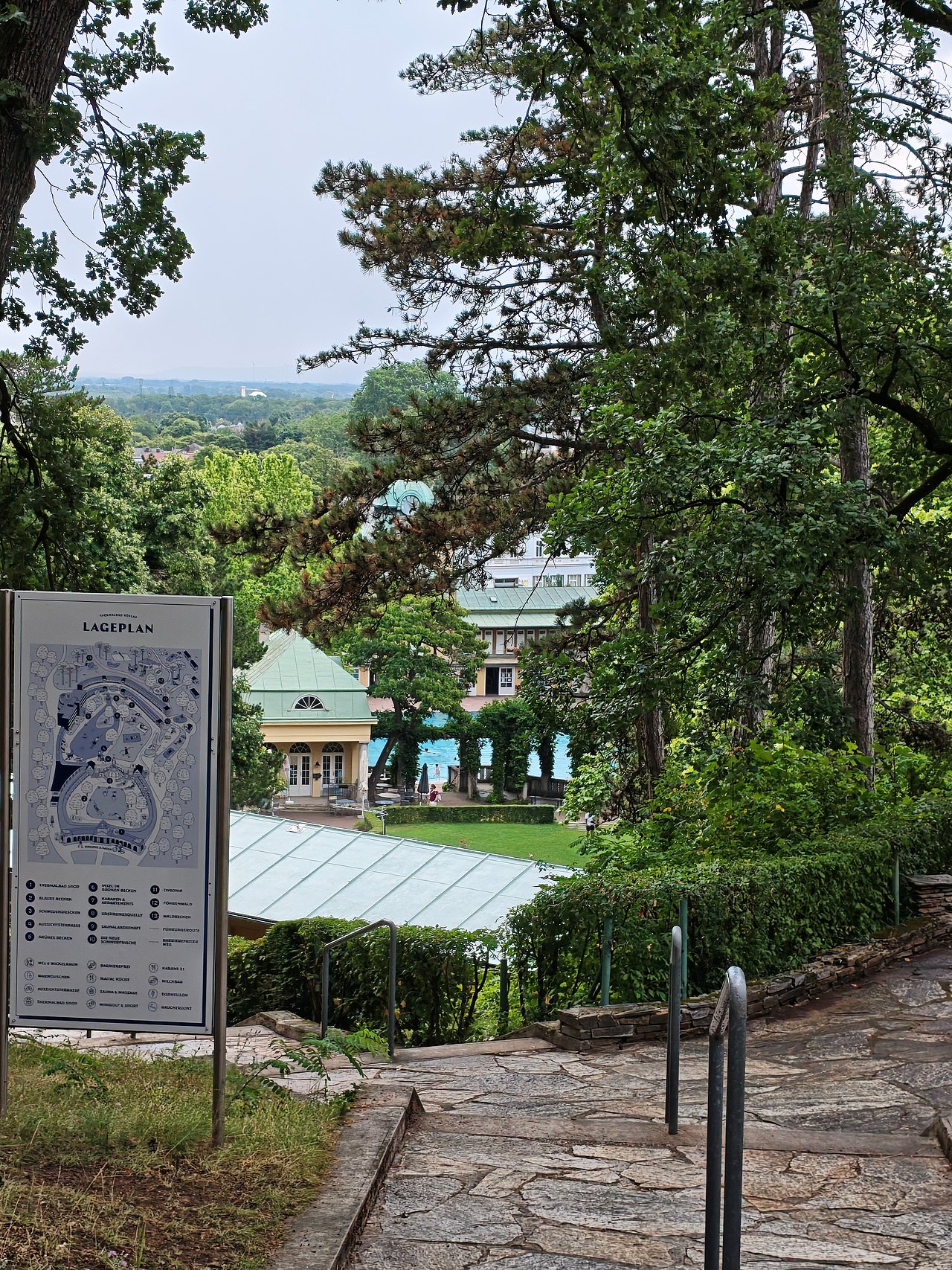 Das Bild zeigt den Ausblick vom Aufgang zum Föhrenwäldchen in Richtung Liegewiese und Blaues Becken.