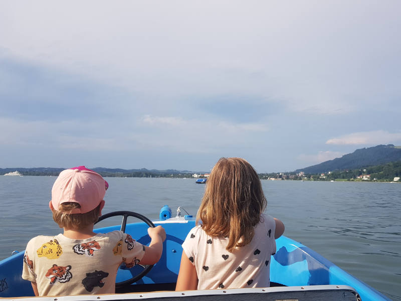 Zwei Kinder sitzen im Elektroboot am Bodensee