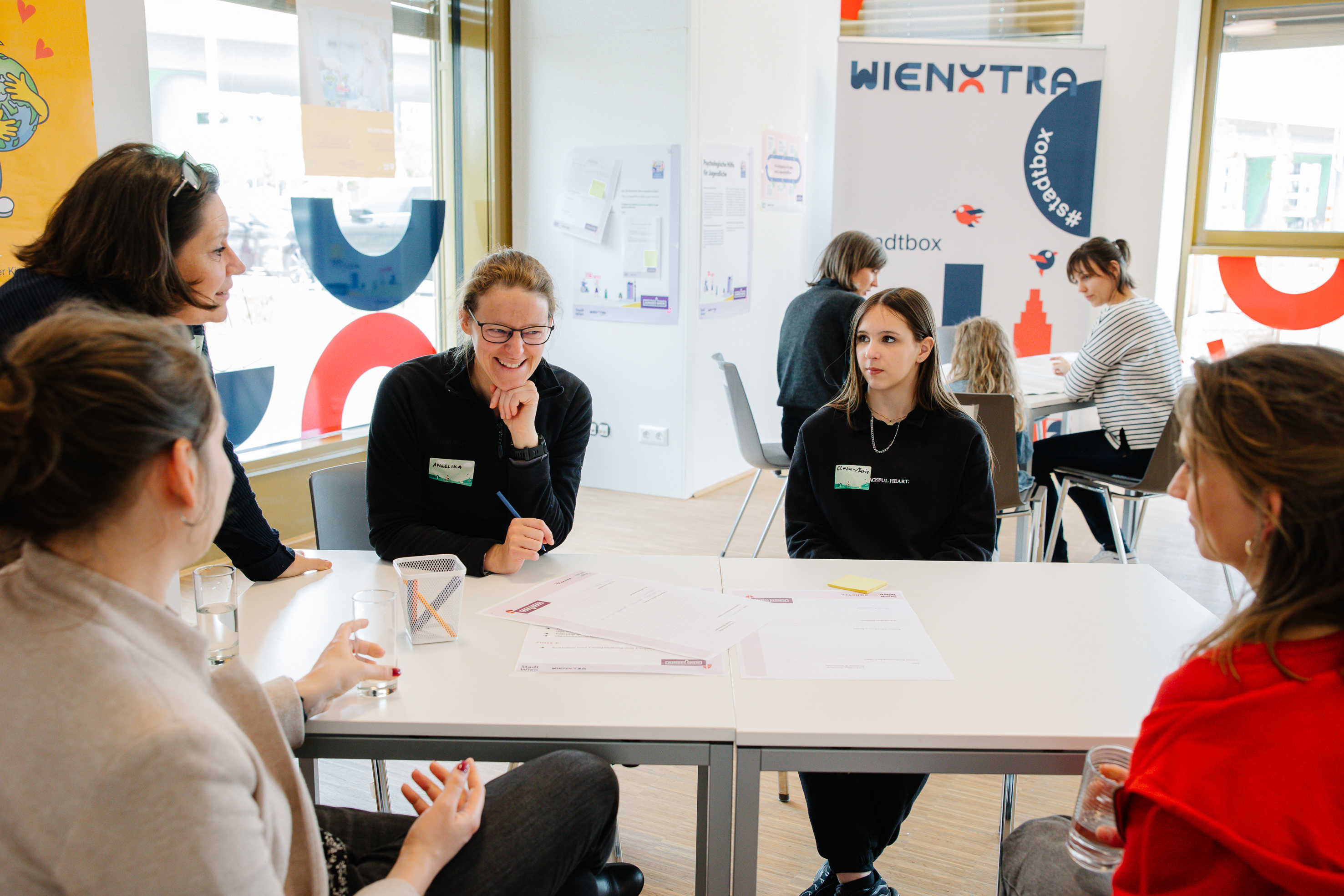 Personen sitzen an einem Tisch und besprechen ein Thema