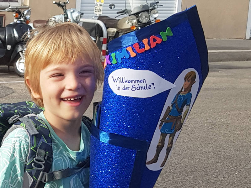 lächelndes Kind mit blauer Schultüte