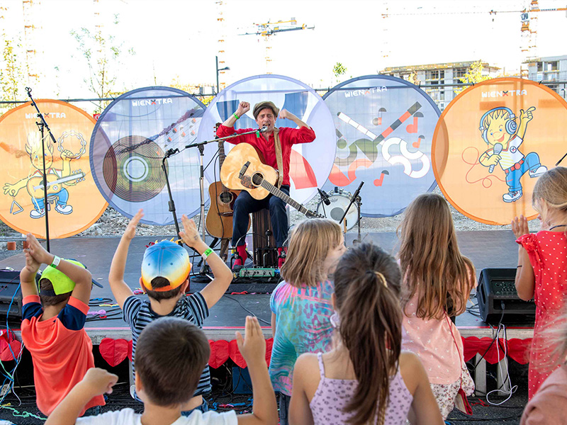 Kinder lauschen Konzert beim Nachbarschaftsfest in der Seestadt bei der WIENXTRA-Stadtbox